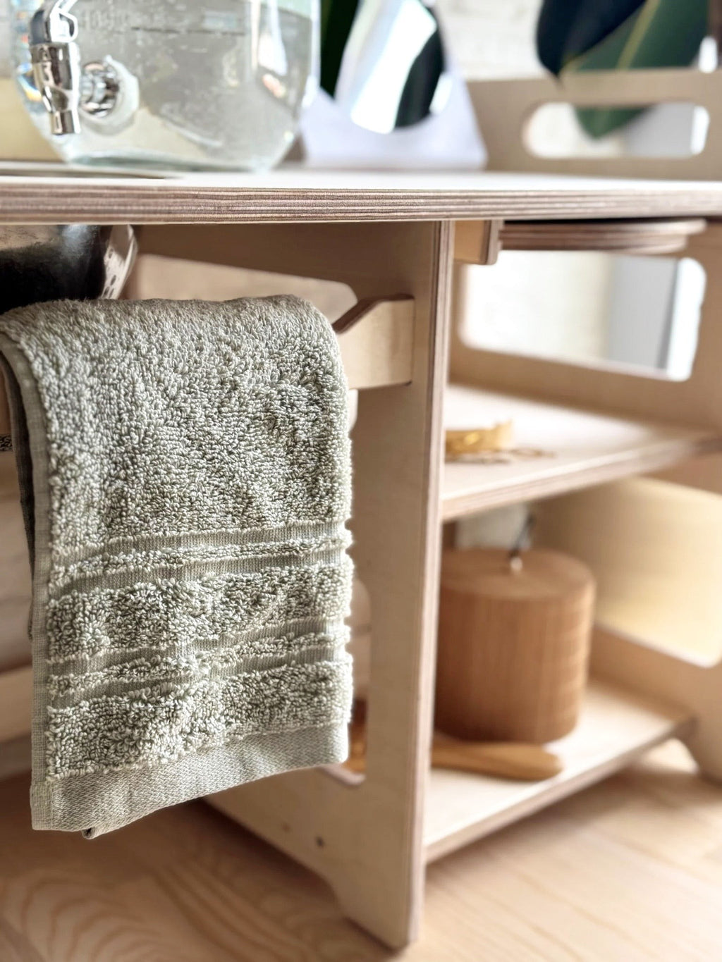 montessori wooden washbasin for toddlers in a bright hallway with a towel and soap