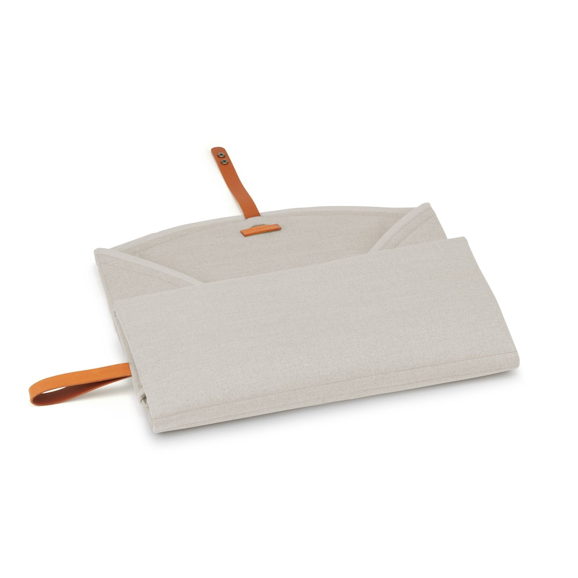 a soft beige dog travel mat with a leather belt, laid out on a cozy carpet