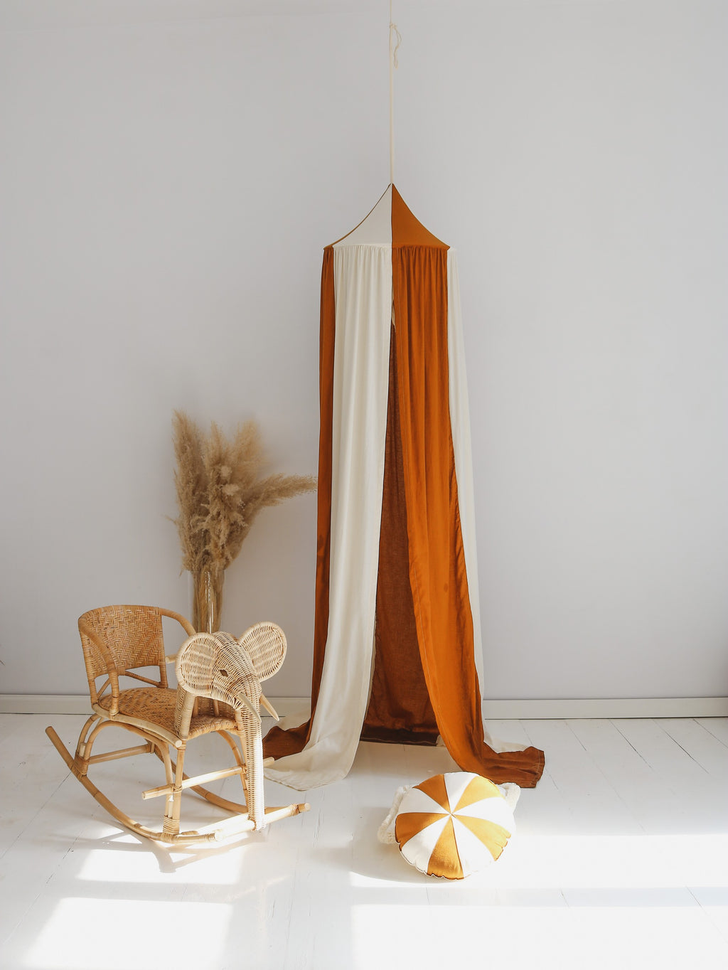 caramel circus organic cotton and linen canopy hanging over a cozy reading nook with soft natural lighting