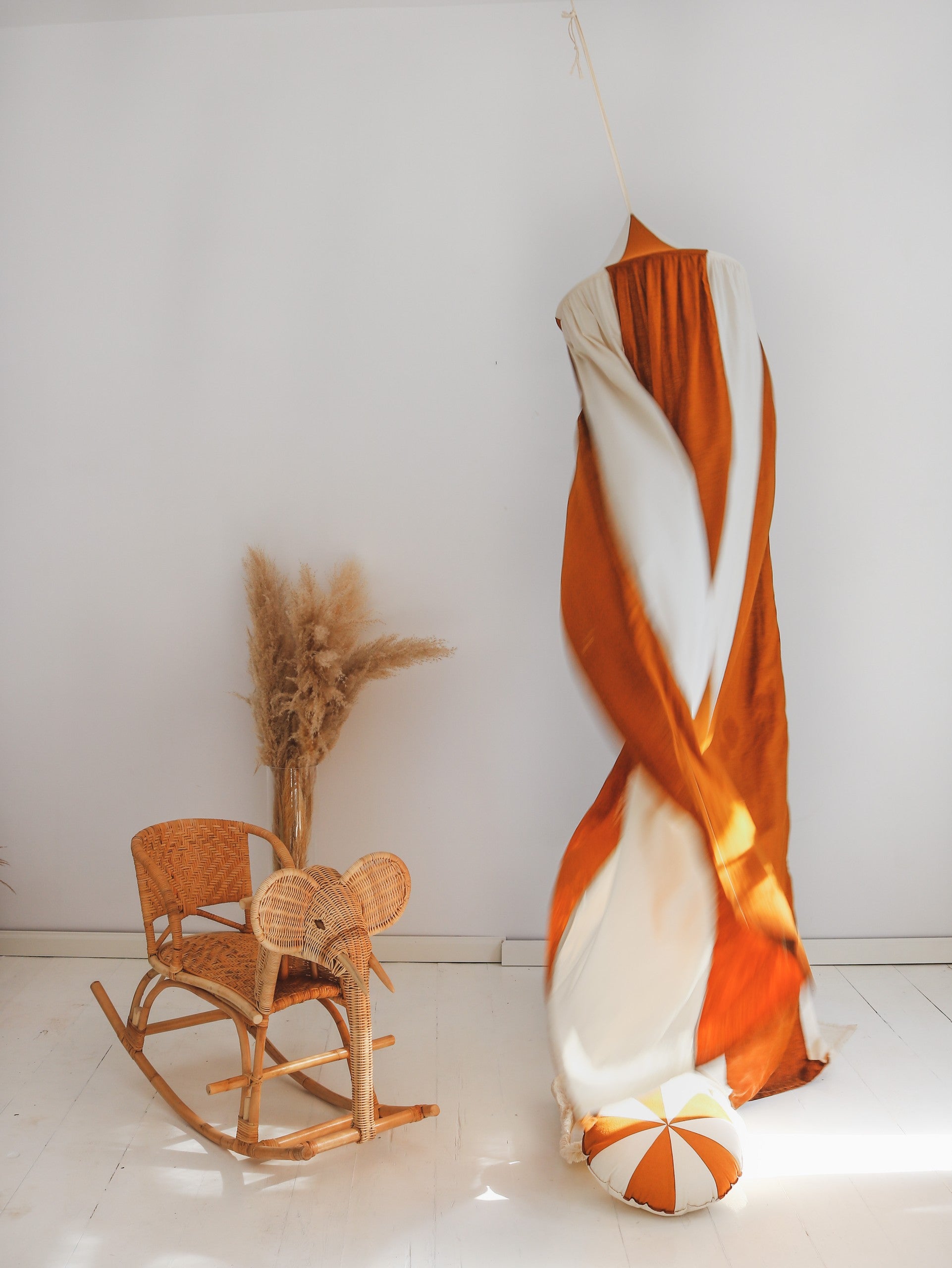 elegant caramel and cream linen canopy hung over a bed with soft ambient lighting