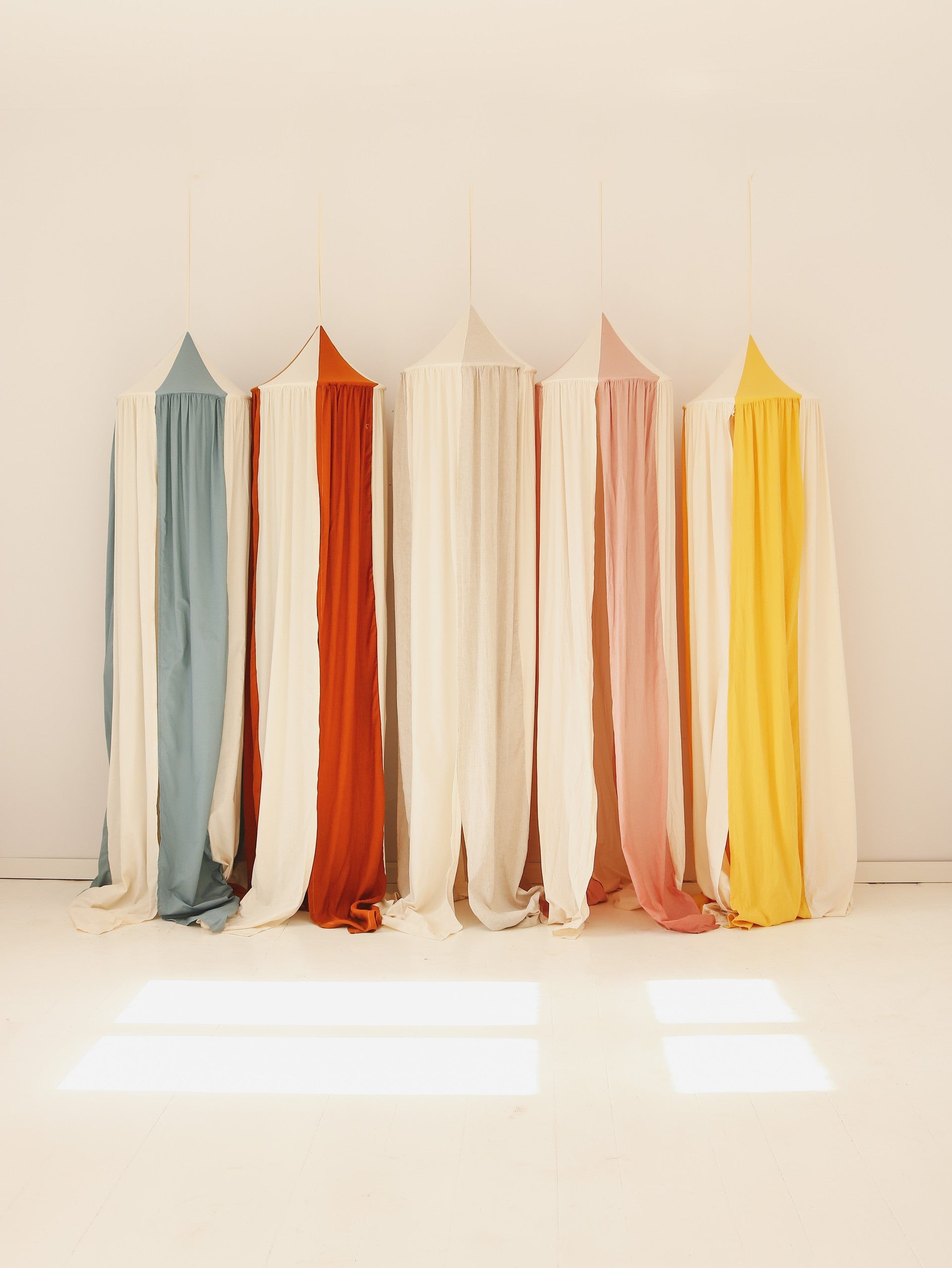 artisan-made cream cotton linen canopy hanging over a bed with soft morning light