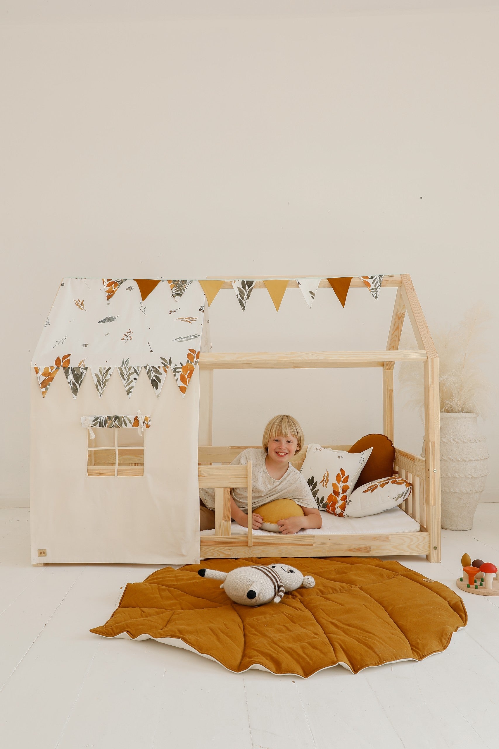 close-up of the caramel leaf playmat's durable stitching and reversible design on a hardwood floor