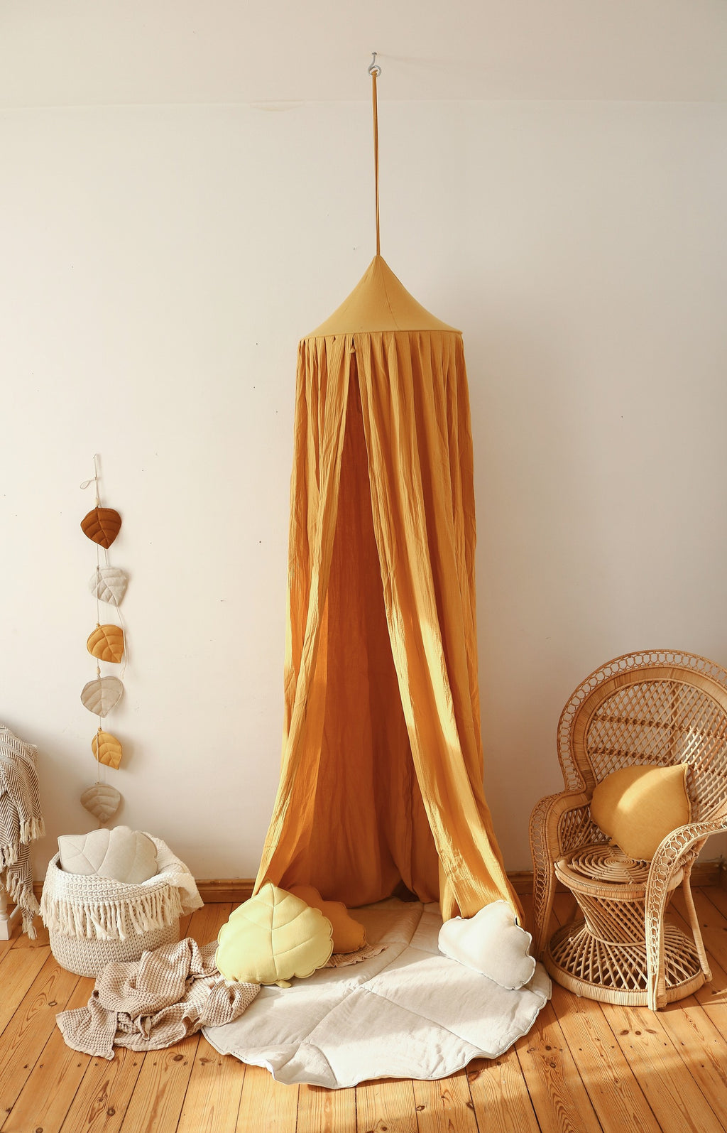 folded organic ginkgo leaf playmat on a shelf showcasing its practical 3cm thickness and sand color