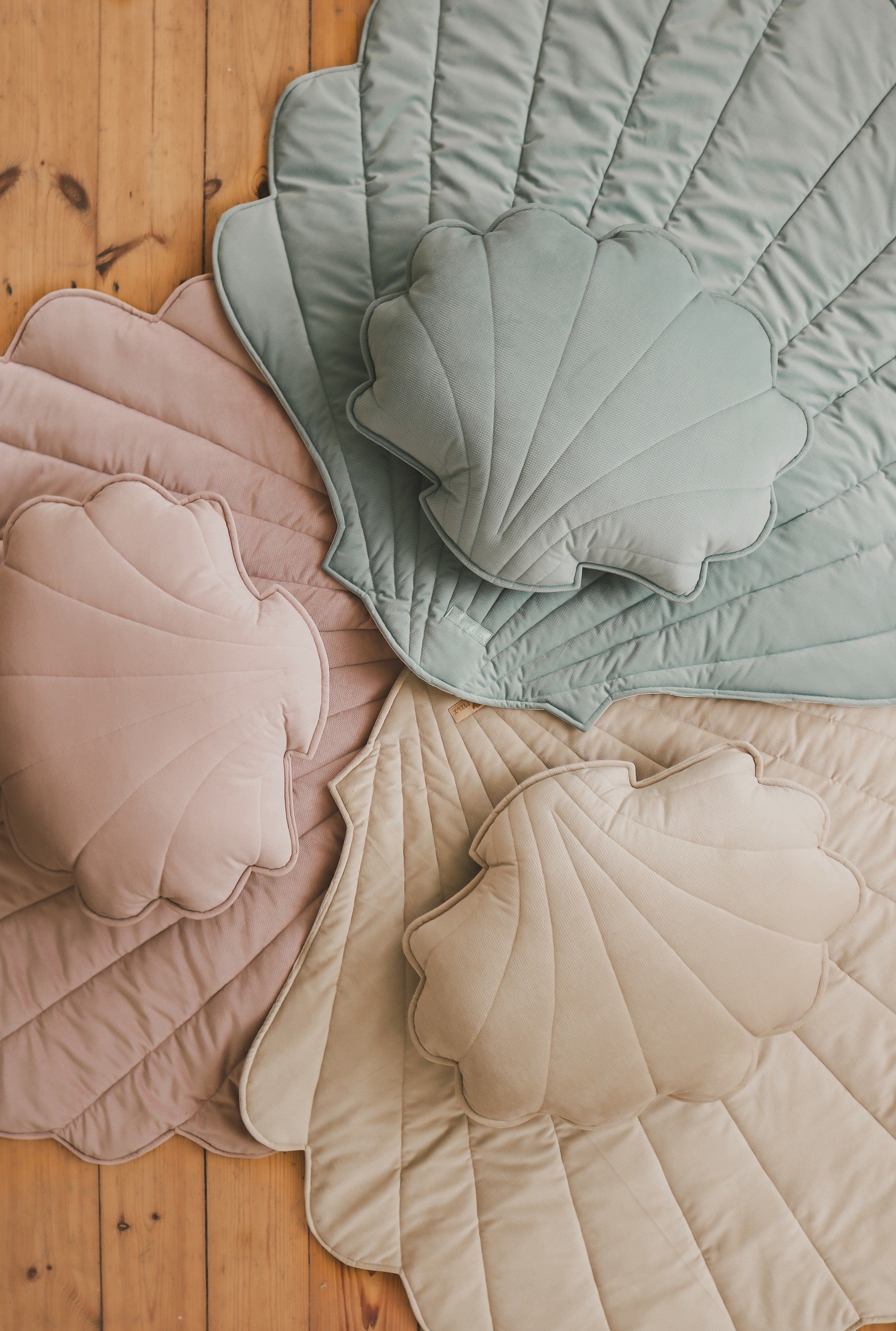 beige ginkgo leaf playmat on a hardwood floor in soft morning light