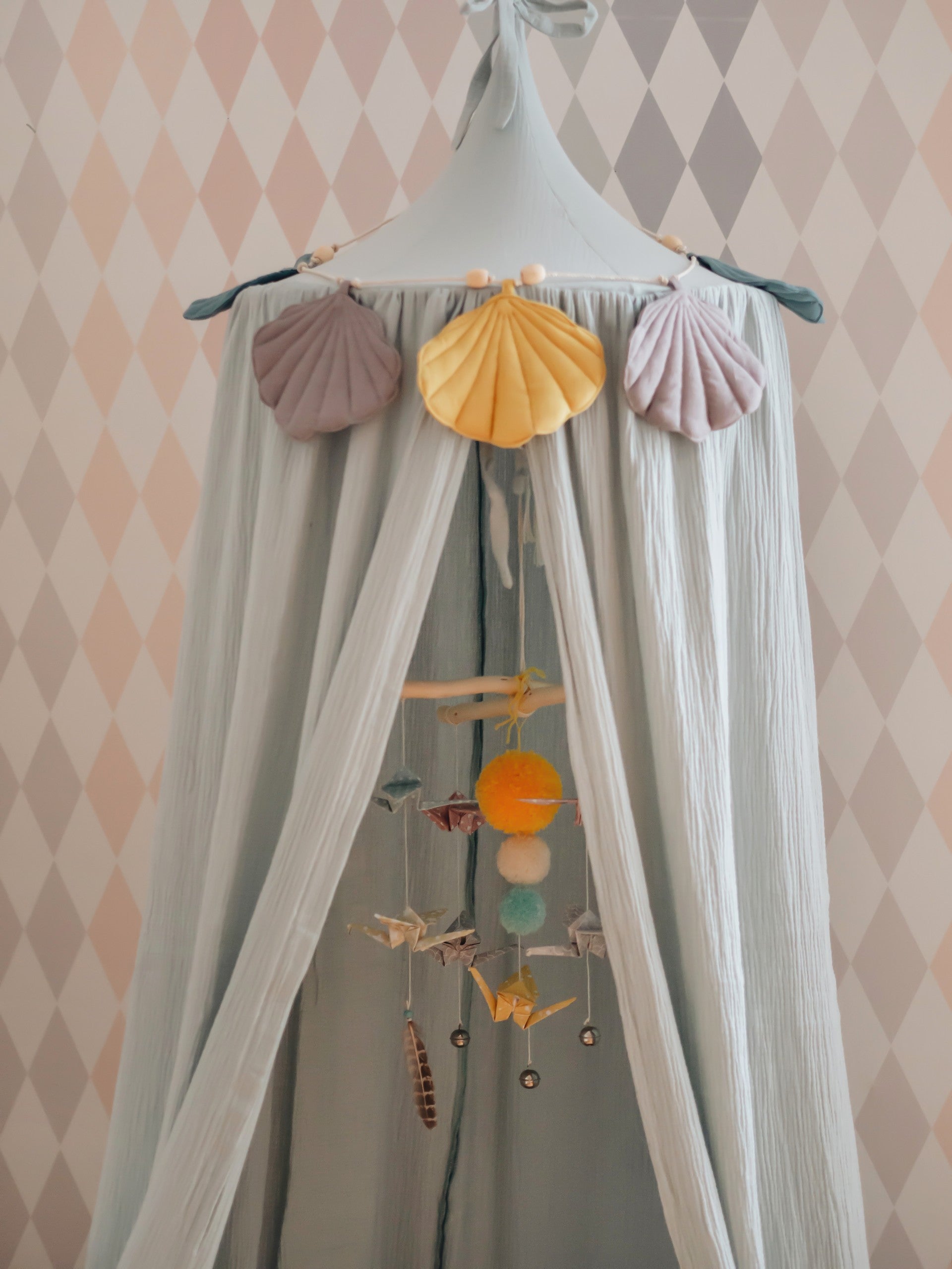 mint green organic cotton canopy hanging over a child's bed with soft morning light