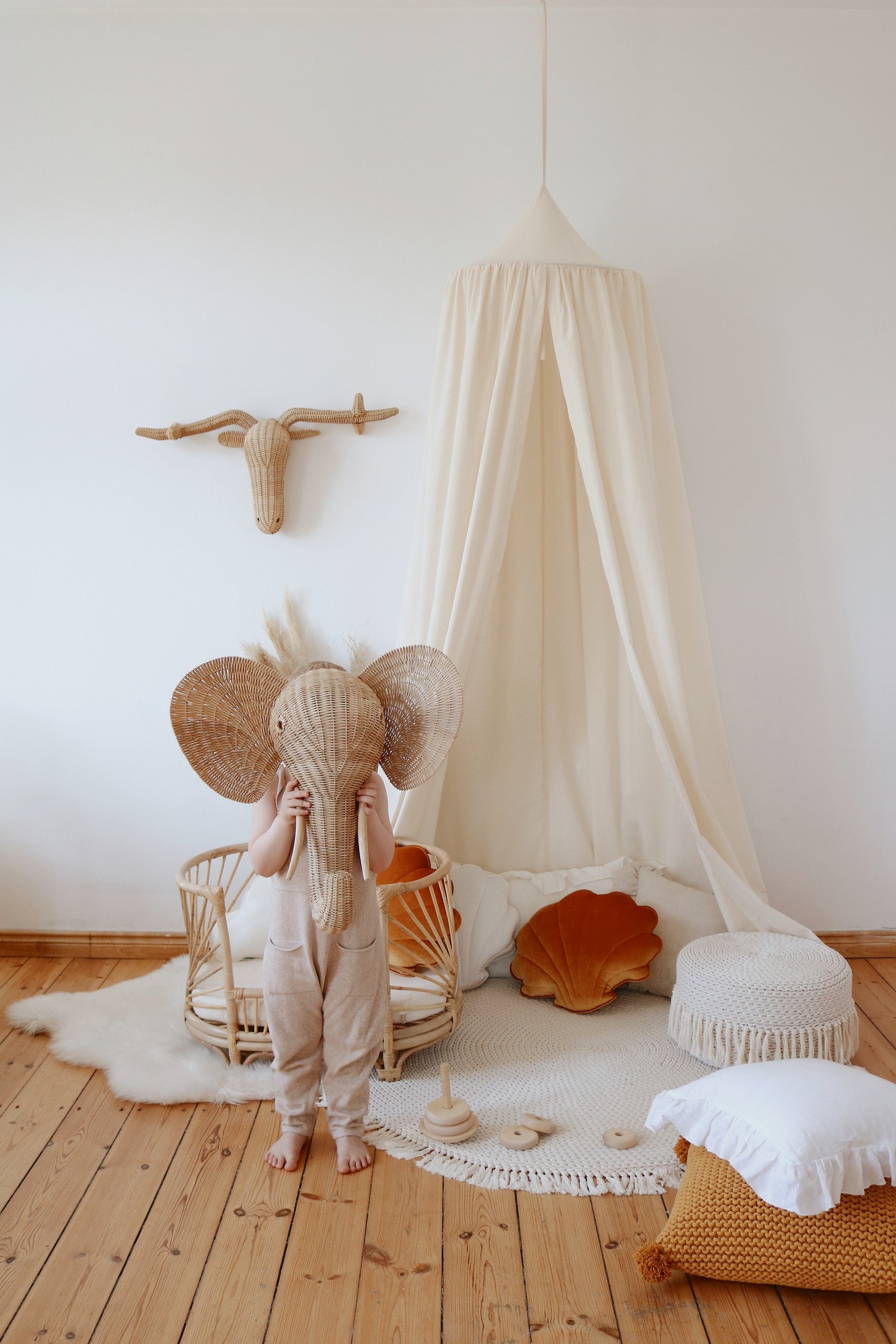 organic cotton canopy hanging over a cozy reading nook with soft natural light filtering through