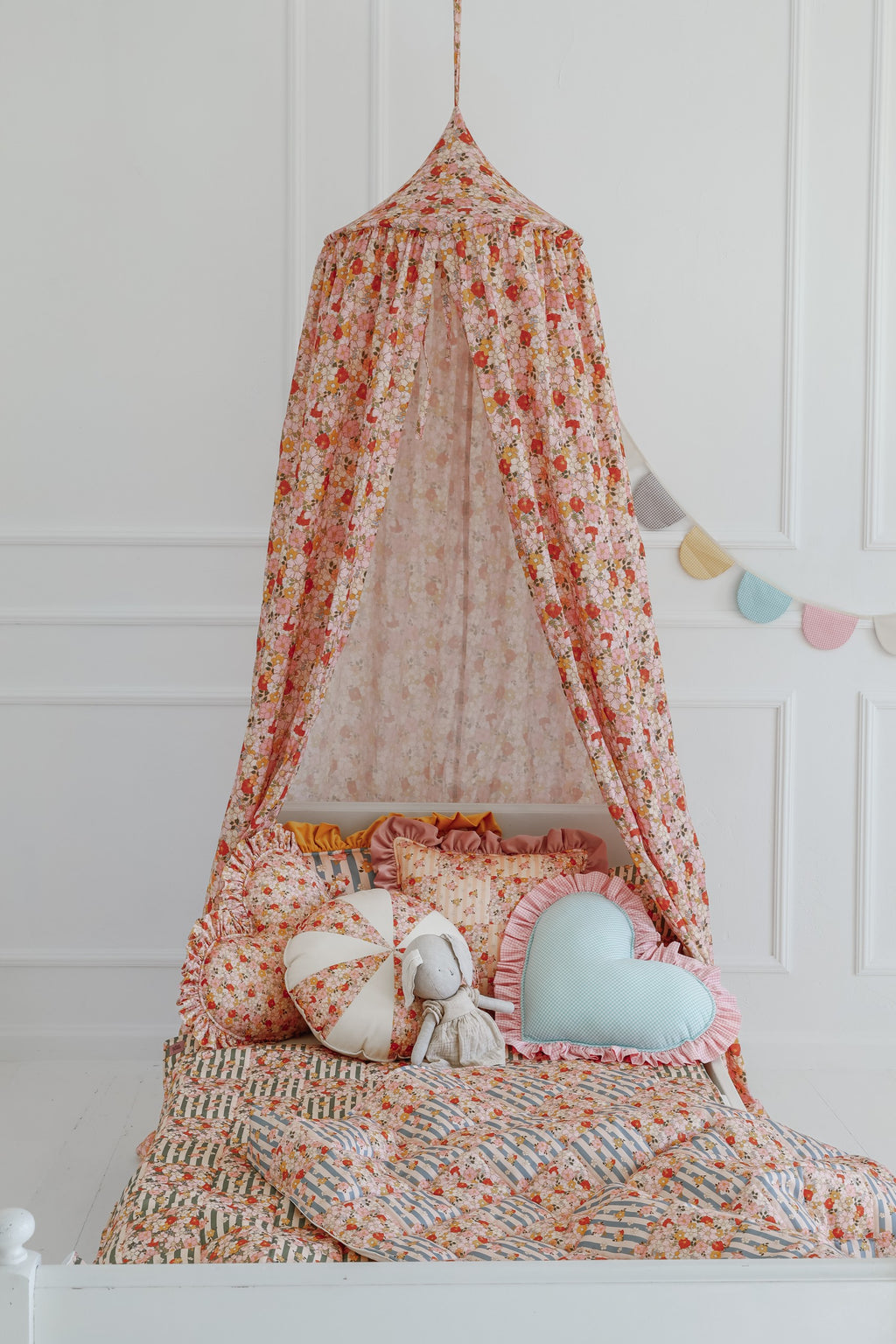 playful mint cotton canopy hanging over a cozy reading nook with soft light filtering through