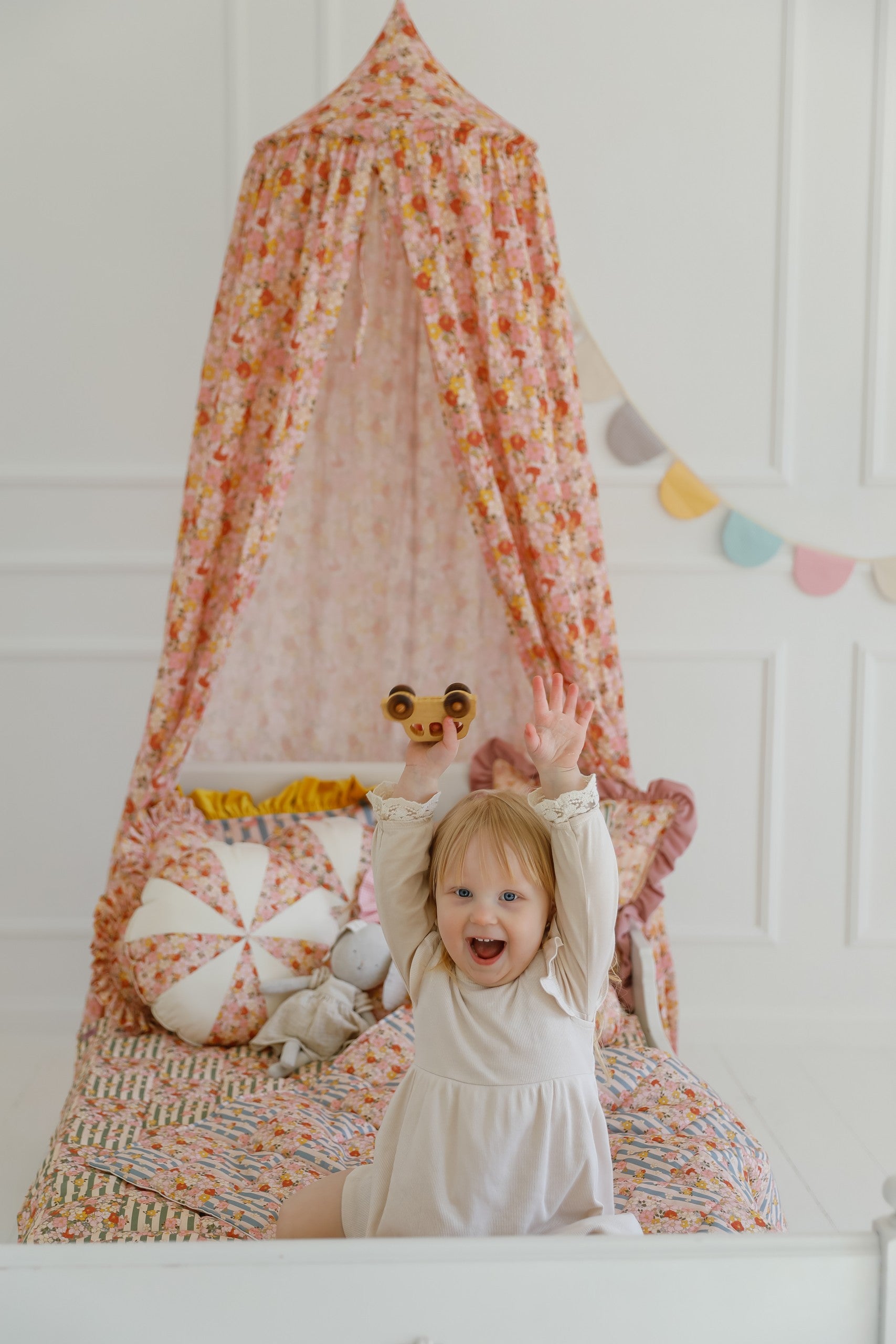mint green organic cotton canopy draped over a child's bed with soft morning light filtering through