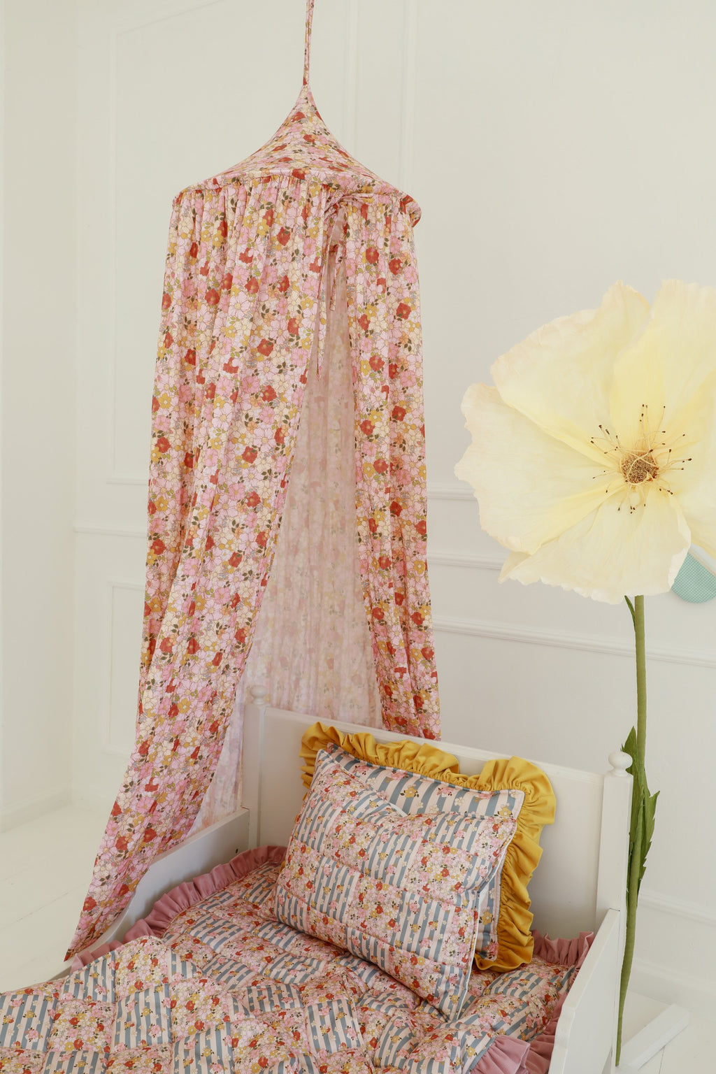 mint organic cotton canopy hanging over a cozy reading nook with soft natural light filtering through