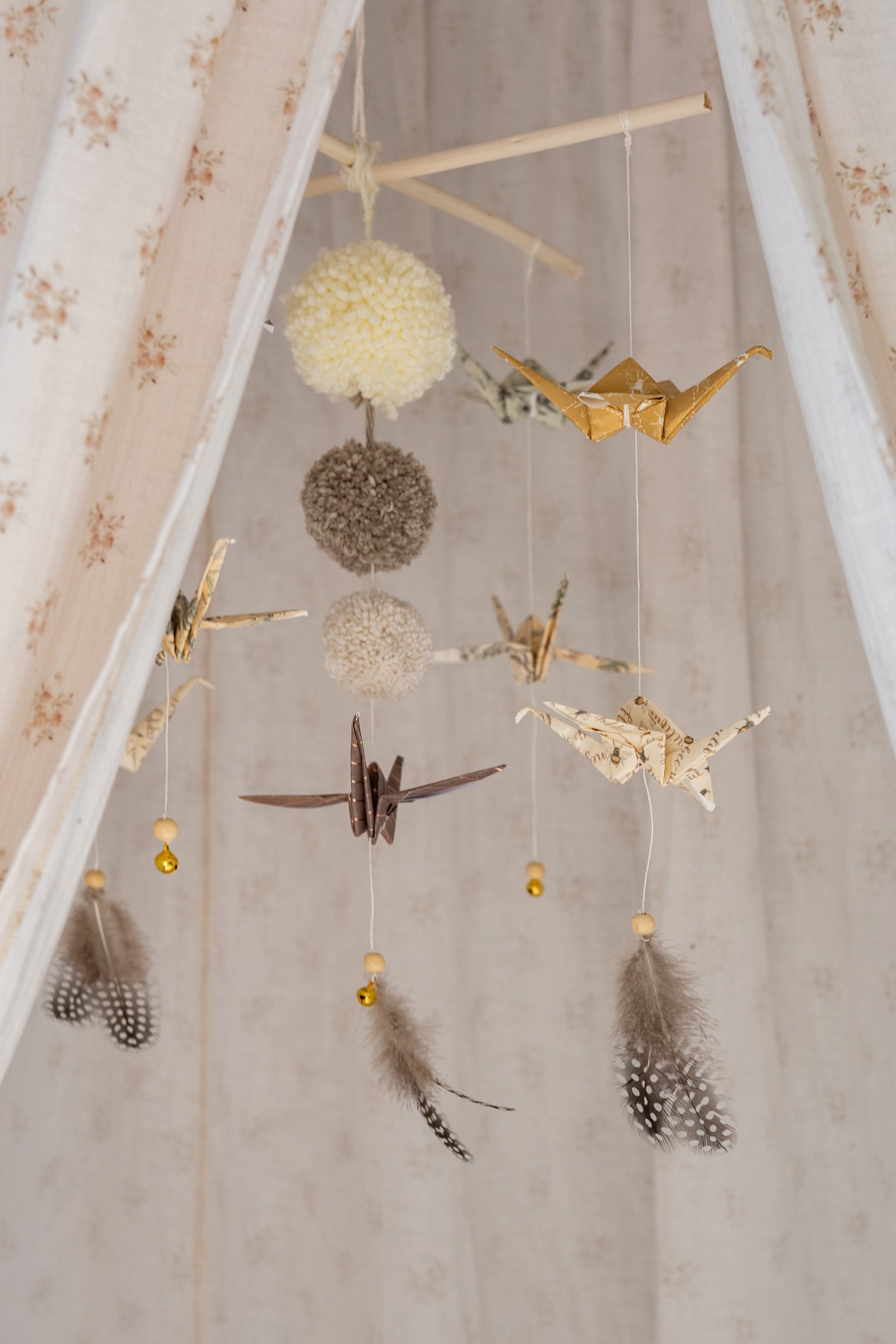 elegant gold-dusted origami mobile in a minimalist nursery with soft morning light