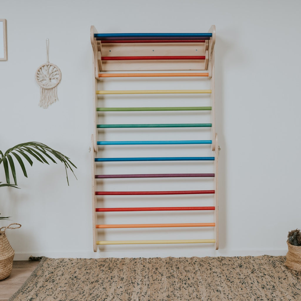 a child's hand reaching for the vibrant rainbow climber rungs during playful indoor adventures