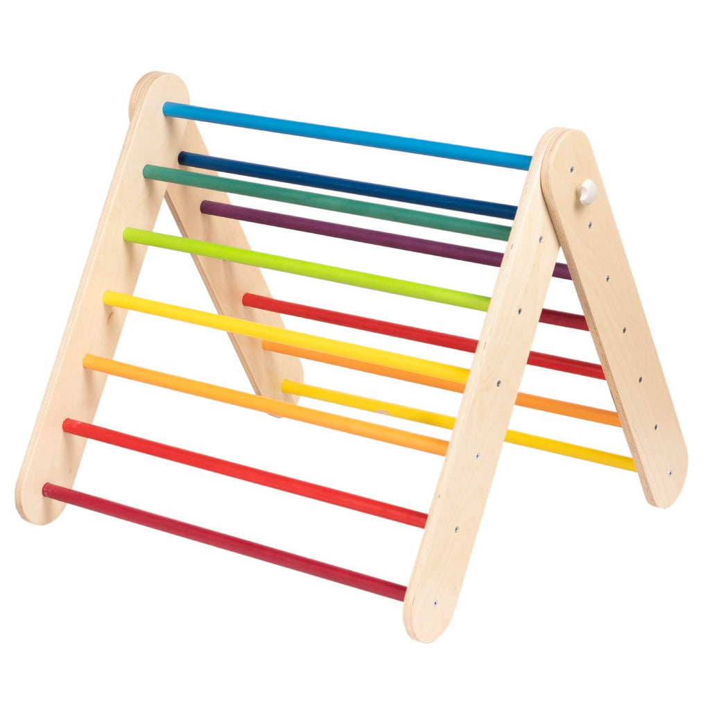 a child's hand reaching for the vibrant rainbow climber in soft morning light
