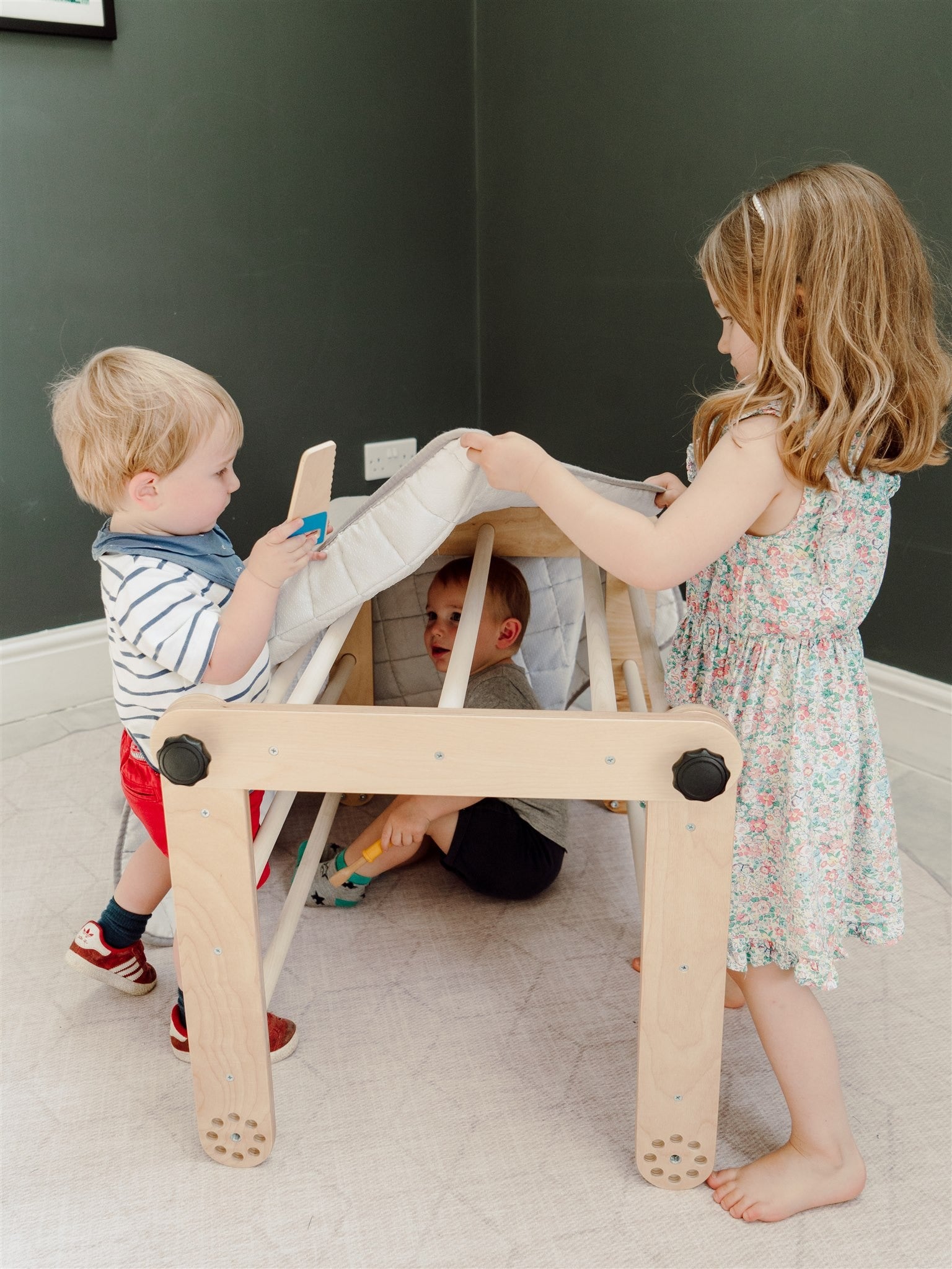 pikler triangle in a cozy nursery corner with soft morning light
