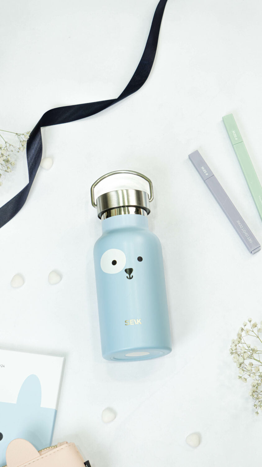 playful blue puppy thermos held by a child in a sunny park
