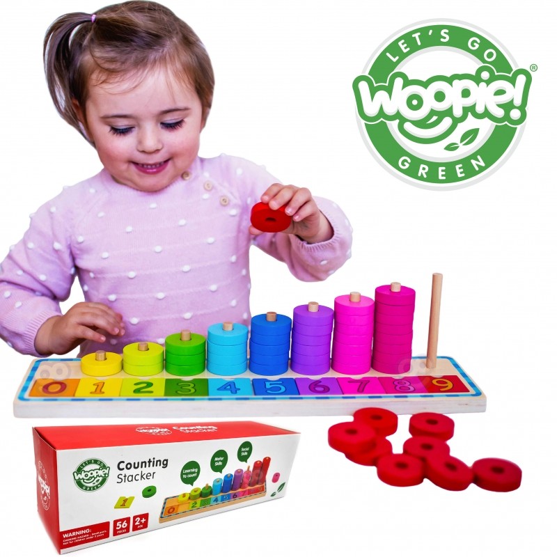 a child's hand placing a green counting puzzle piece onto the wooden board
