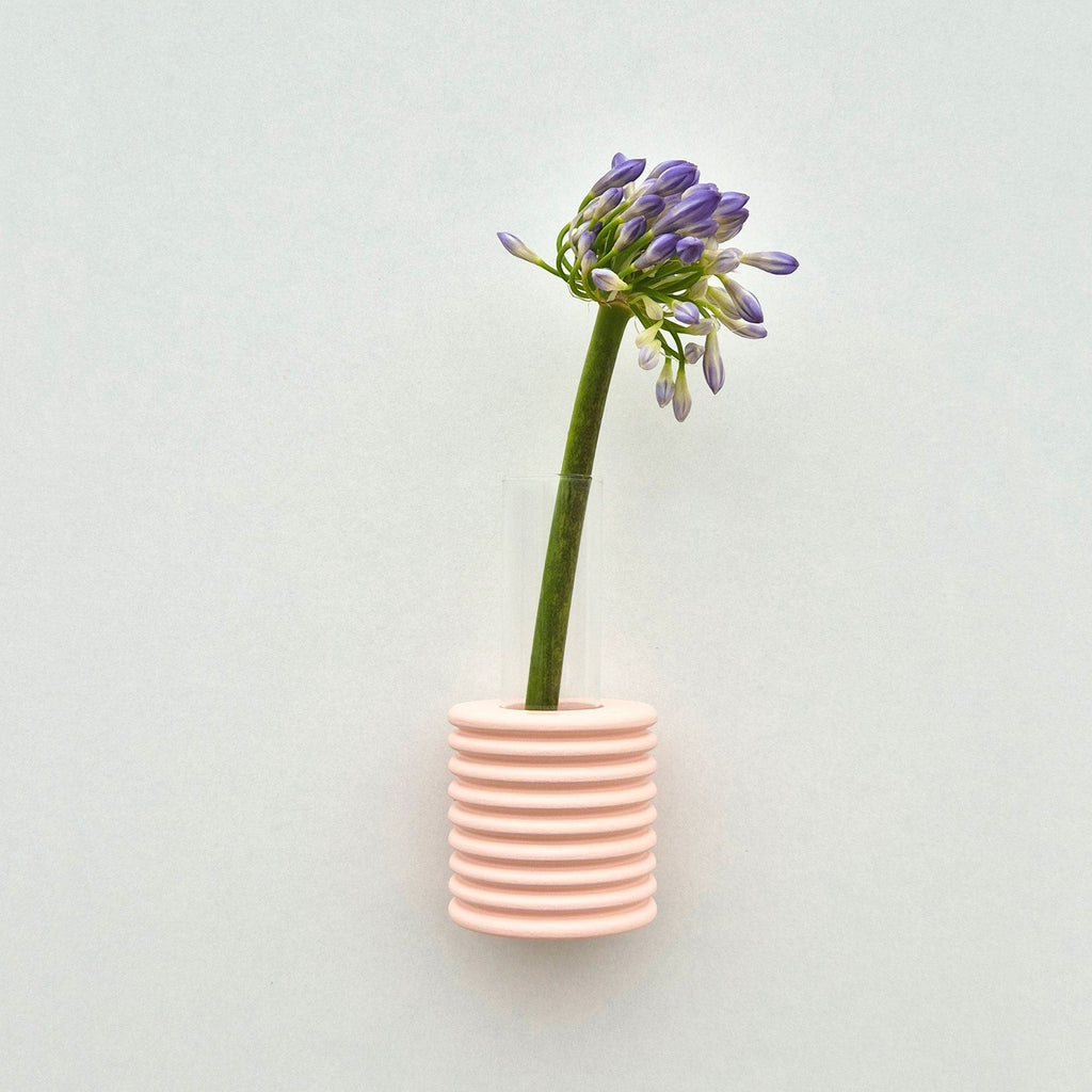 bold pink ribble wall vase made of beech wood with a dramatic close-up angle