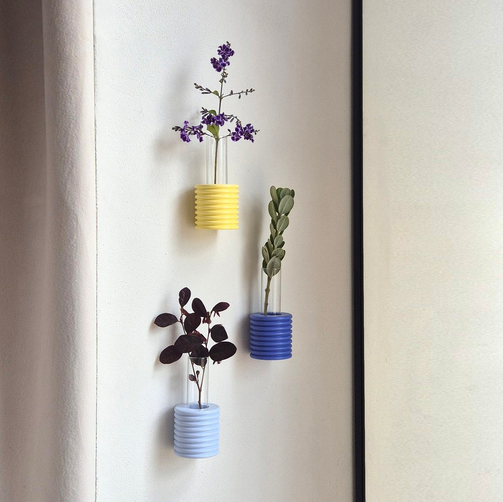 elegant handmade yellow beech wood wall vase with a single stem on a minimalist backdrop