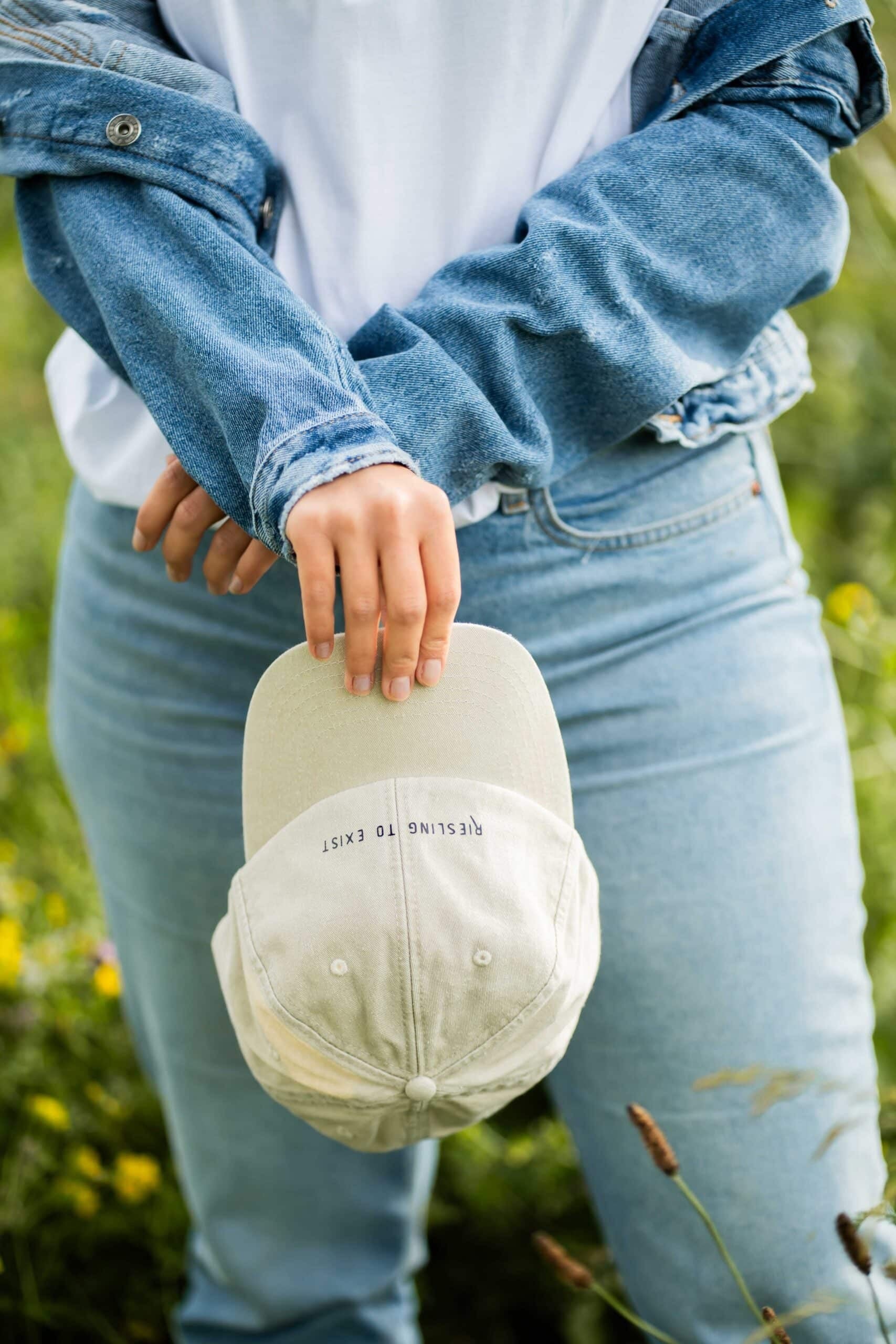 riesling to exist cotton cap shown from a practical side angle, highlighting the adjustable fabric strap closure for a custom fit