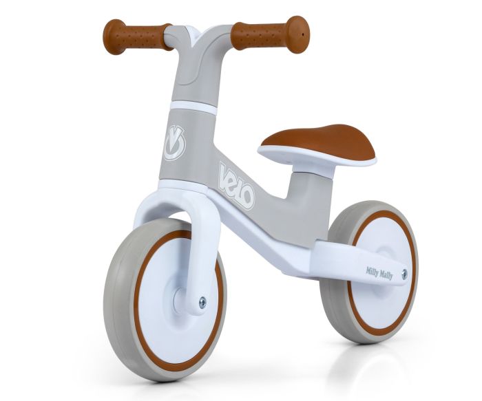 a toddler laughing on a lightweight blue velo balance bike in a sunny park