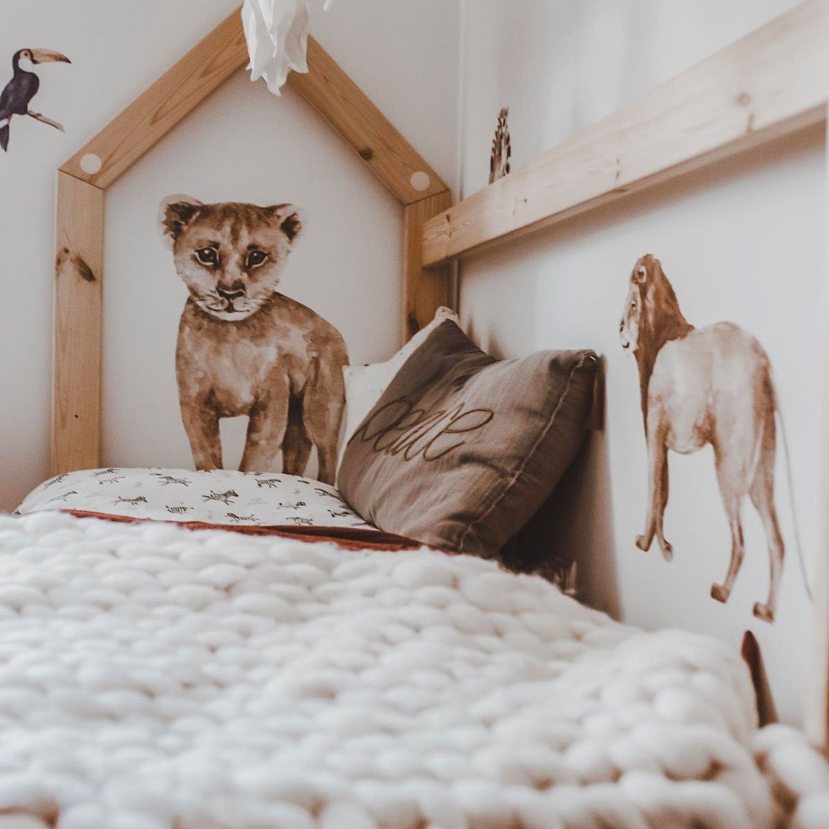 a playful lemur from the savanna wonderland wallstickers set peeking from a nursery wall