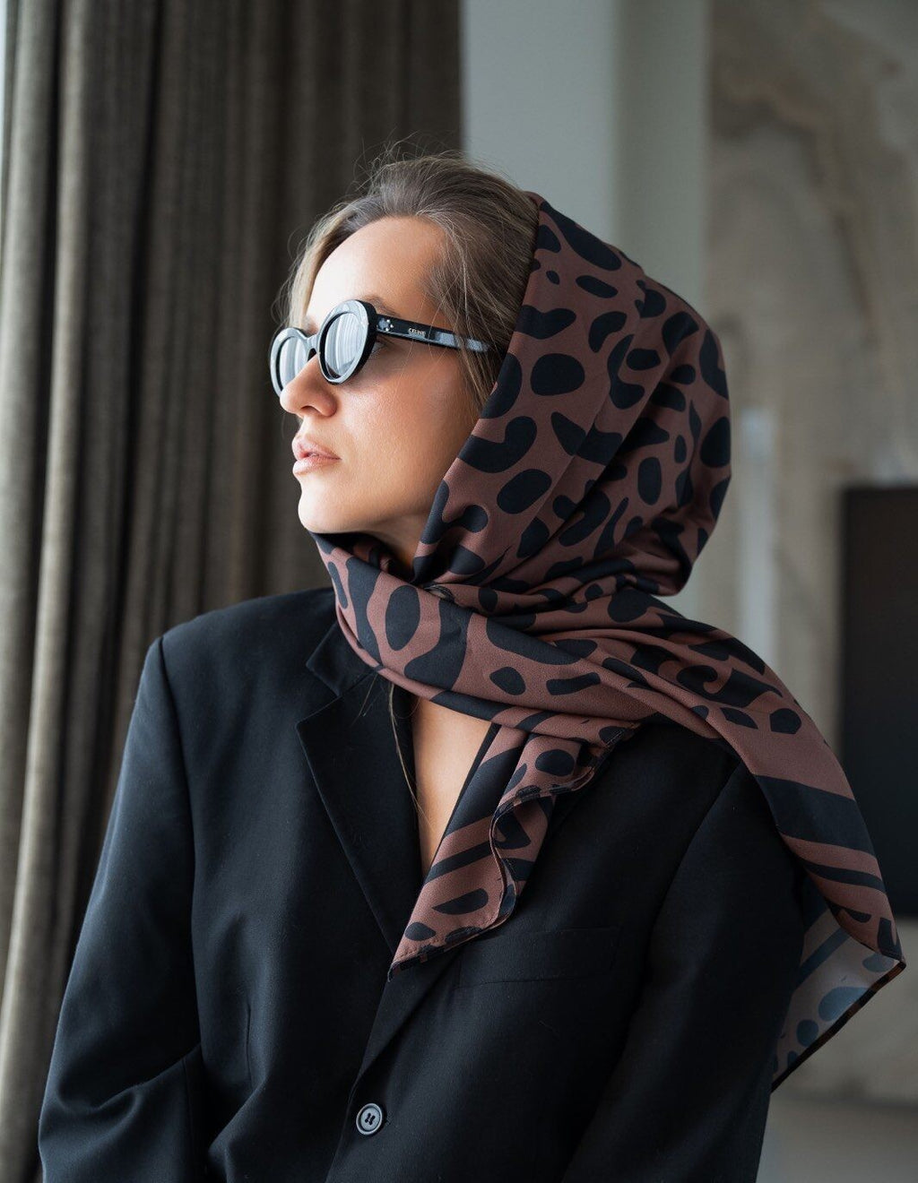 soft leopard print scarf draped gently on a cozy cream knit sweater