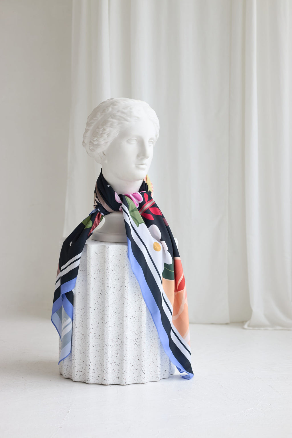 elegant leopard print silk scarf draped over a sunlit garden chair