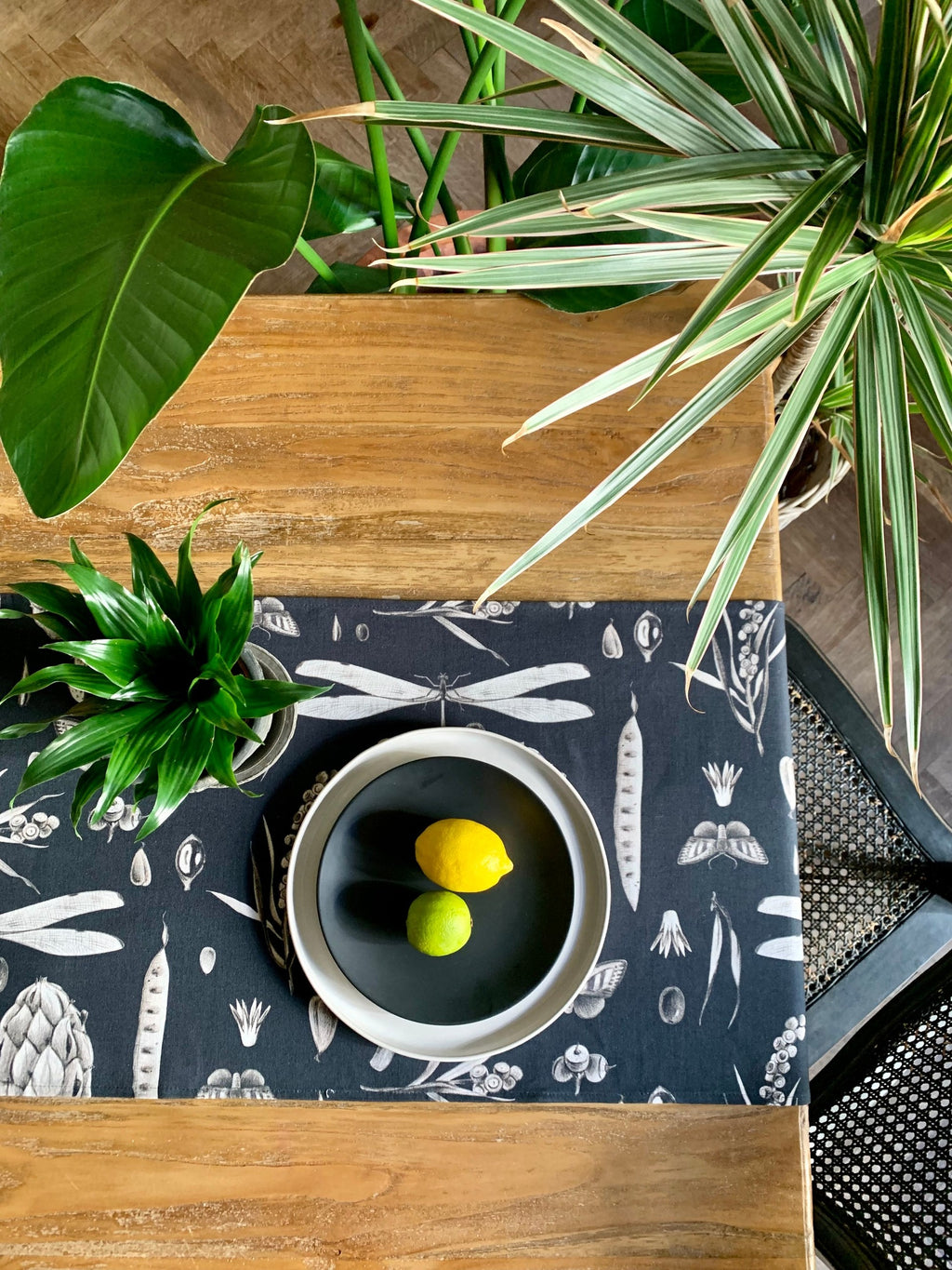 a playful close-up of the seeds carbon cotton table runner on a sunlit table