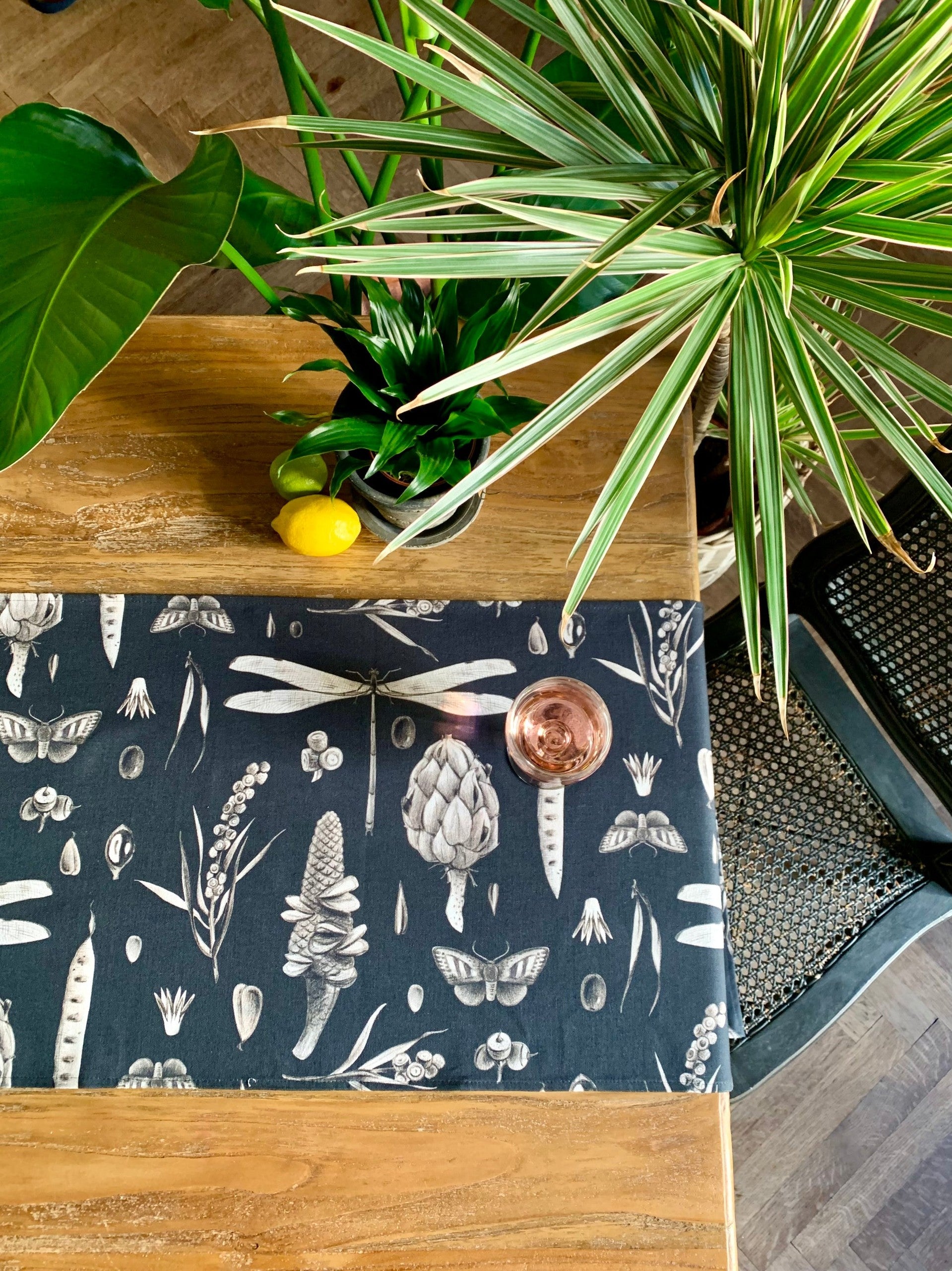 a soft cotton table runner with a seeds carbon print laid gently on a wooden table