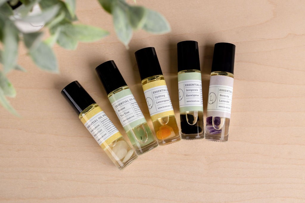 practical close-up of the five crystal-infused essential oil roll-ons in a white gift box