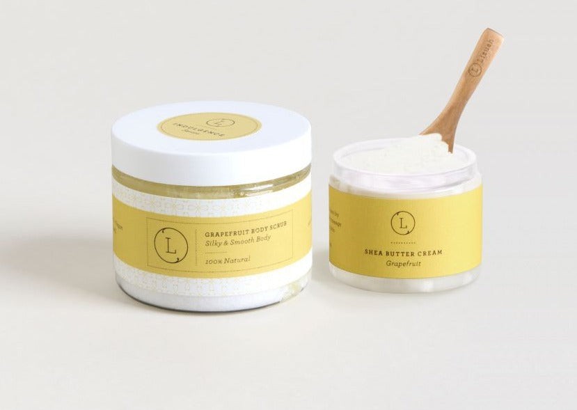 bold close-up of artisan shea butter and grapefruit scrub set with vibrant citrus accents