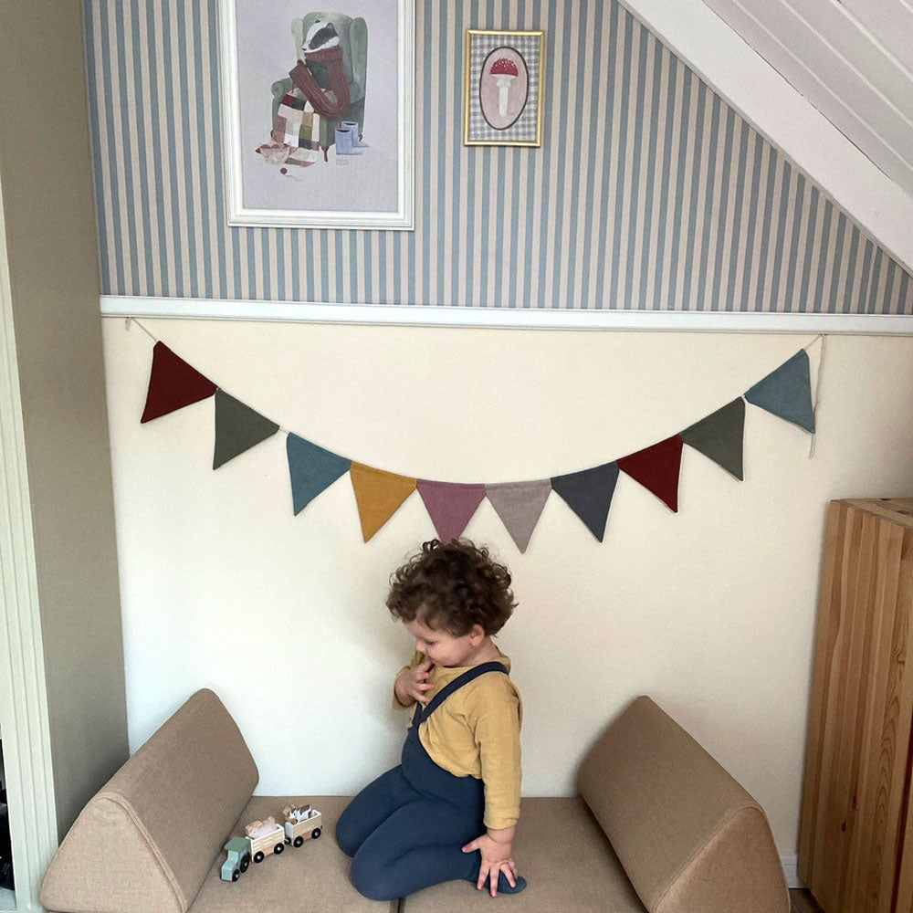 soft beige and blue vintage stripe wallpaper sample in a cozy nursery with gentle morning light