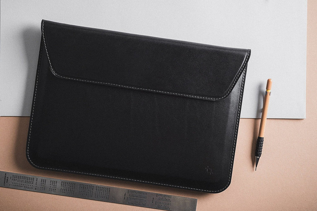 playful shot of the slim note sack laptop sleeve on a colorful desk