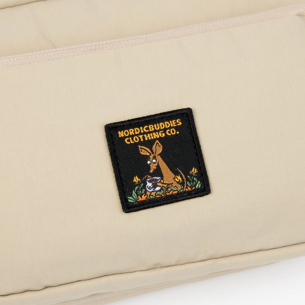 playful beige moomin waist bag with snif on a sunny park bench