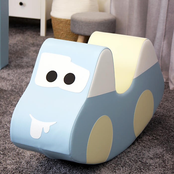 a playful toddler driving a light blue iglu soft play car on a sunny day
