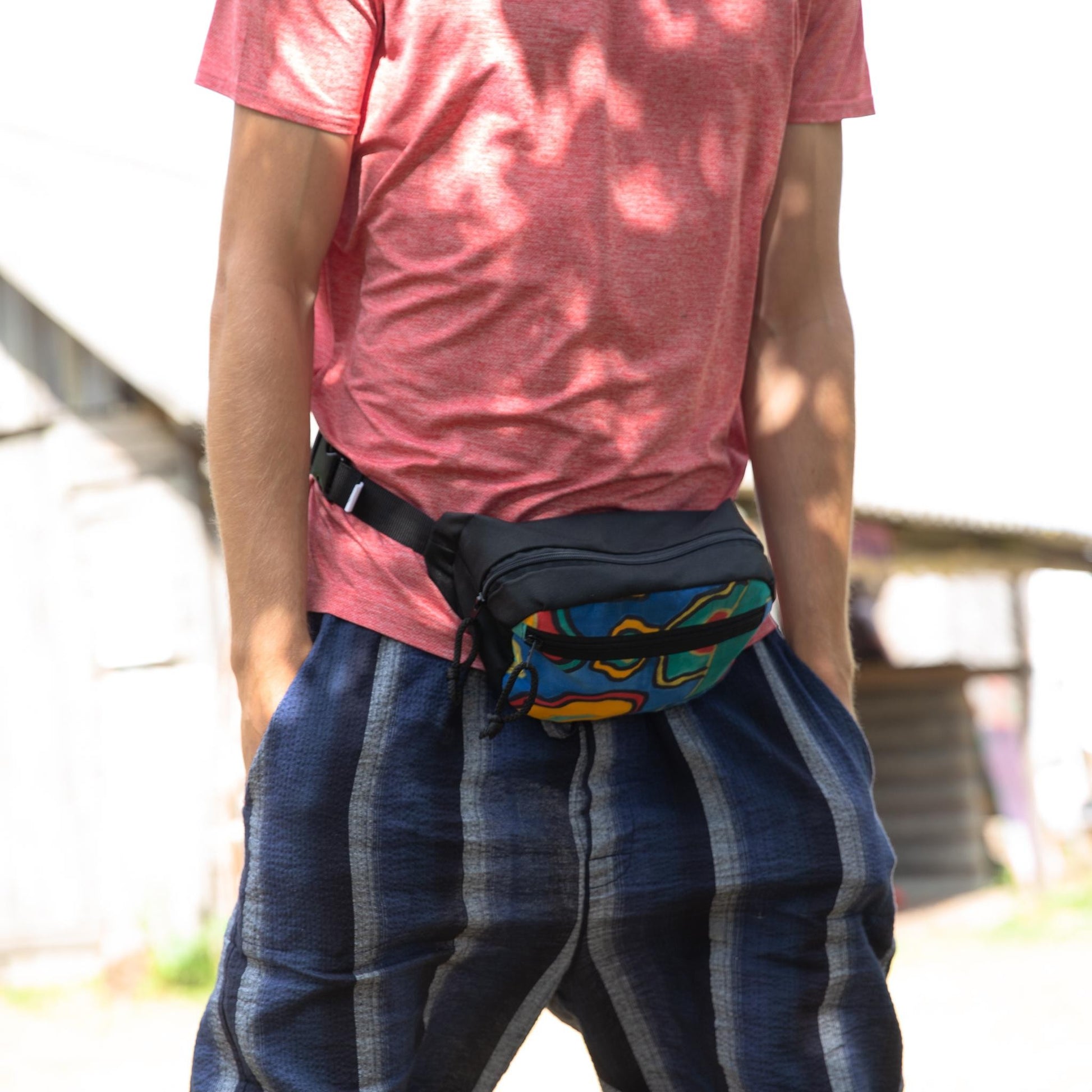 a playful close-up of the handmade africa waist bag with a water bottle in its main compartment