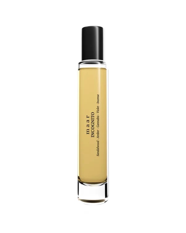 softly lit incognito perfume bottle resting on a sandy surface, evoking a serene beachside tranquility
