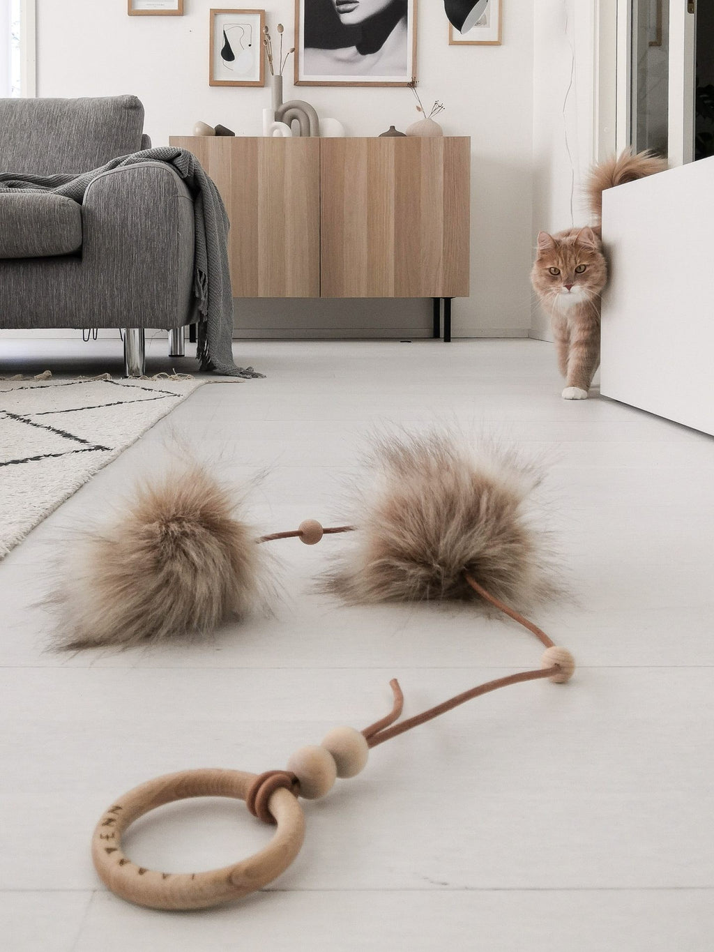 soft cappuccino cat toy with two fluffy balls on a cozy bed, inviting gentle play