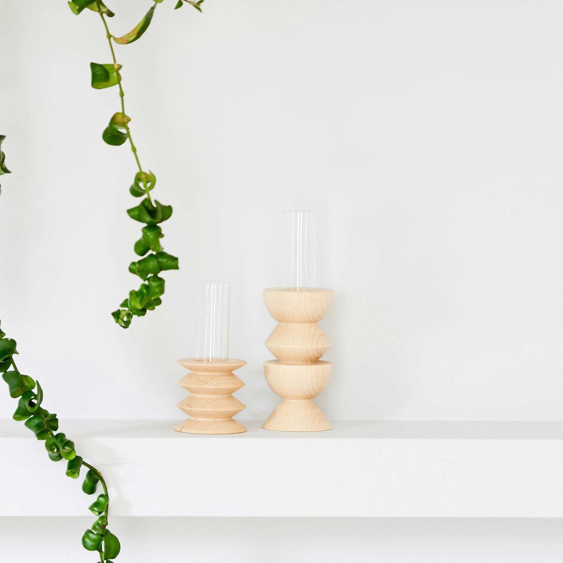 playful short totem wooden vase with a single vibrant flower on a bright windowsill