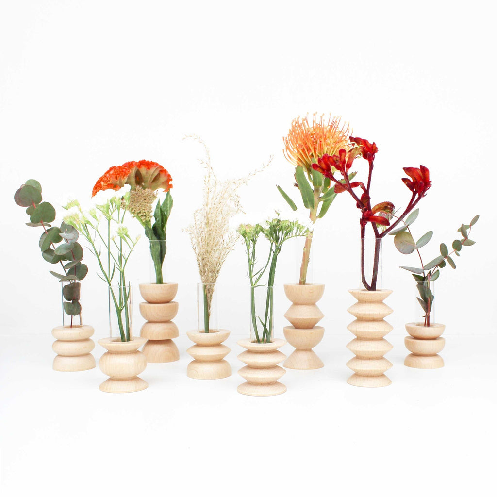 elegant beech wood vase with glass tube on a minimalist table, showcasing its refined artisan quality
