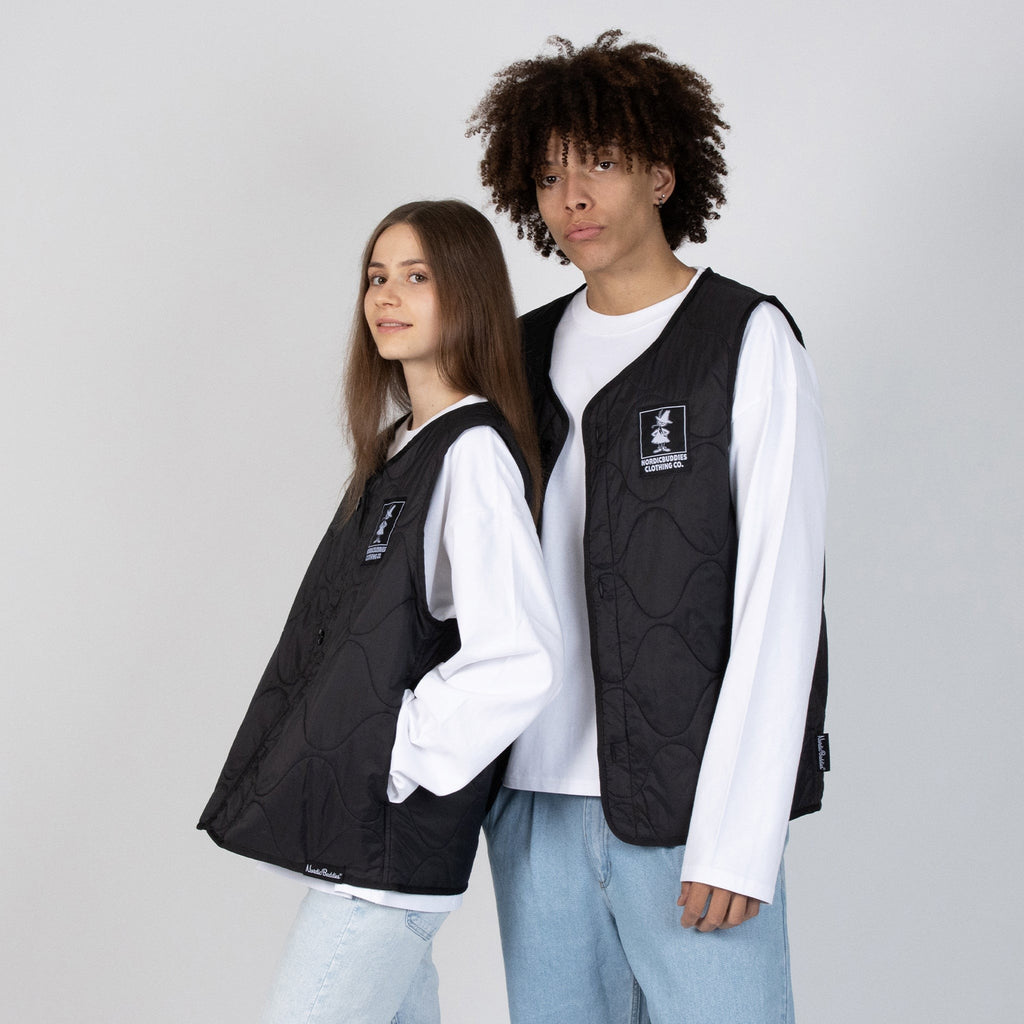 confident adventurer in a black snufkin fishing vest against a rugged outdoor backdrop