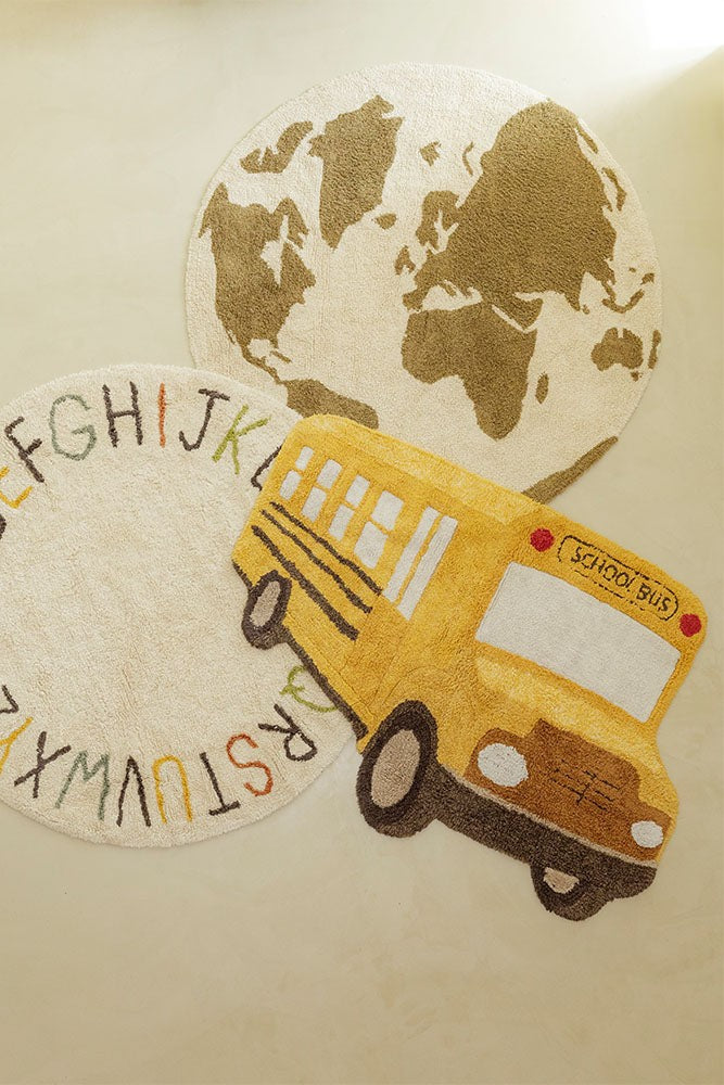a playful school bus rug with embroidered details on a sunny yellow floor
