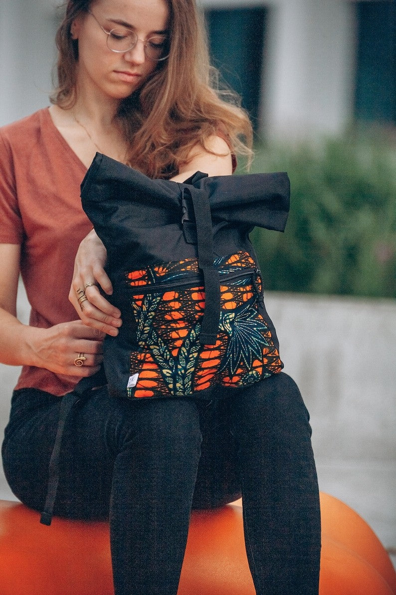 bold yellow patterned waterproof rolltop backpack open to show its spacious compartments