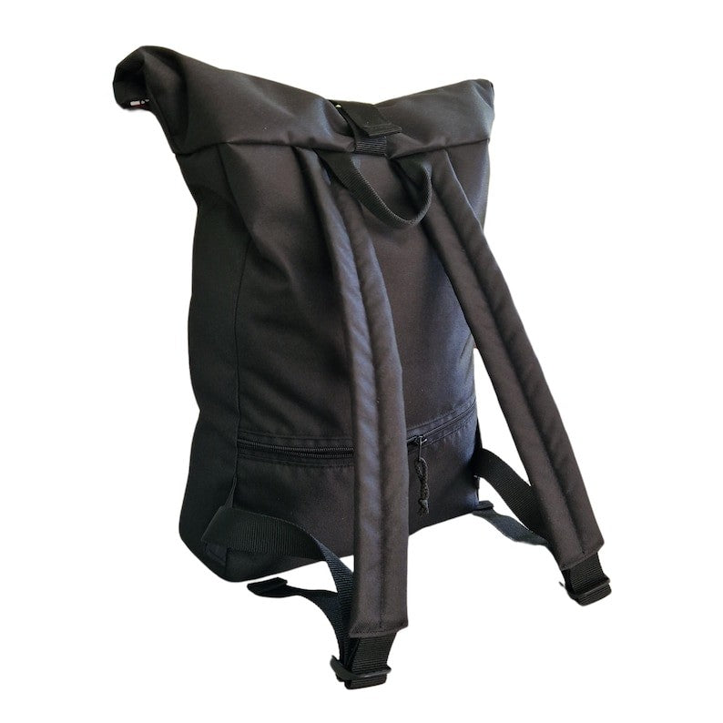 a playful yellow patterned waterproof backpack on a sunny adventure, showing its rolltop closure