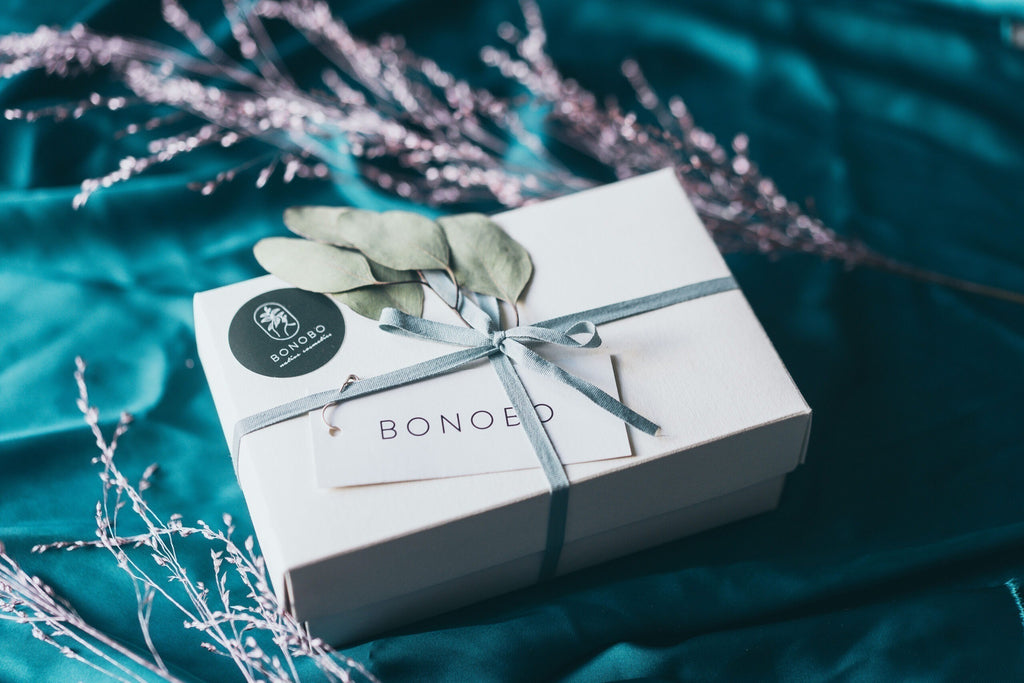 a playful close-up of the with love gift box showing the avocado lip balm and orange cream