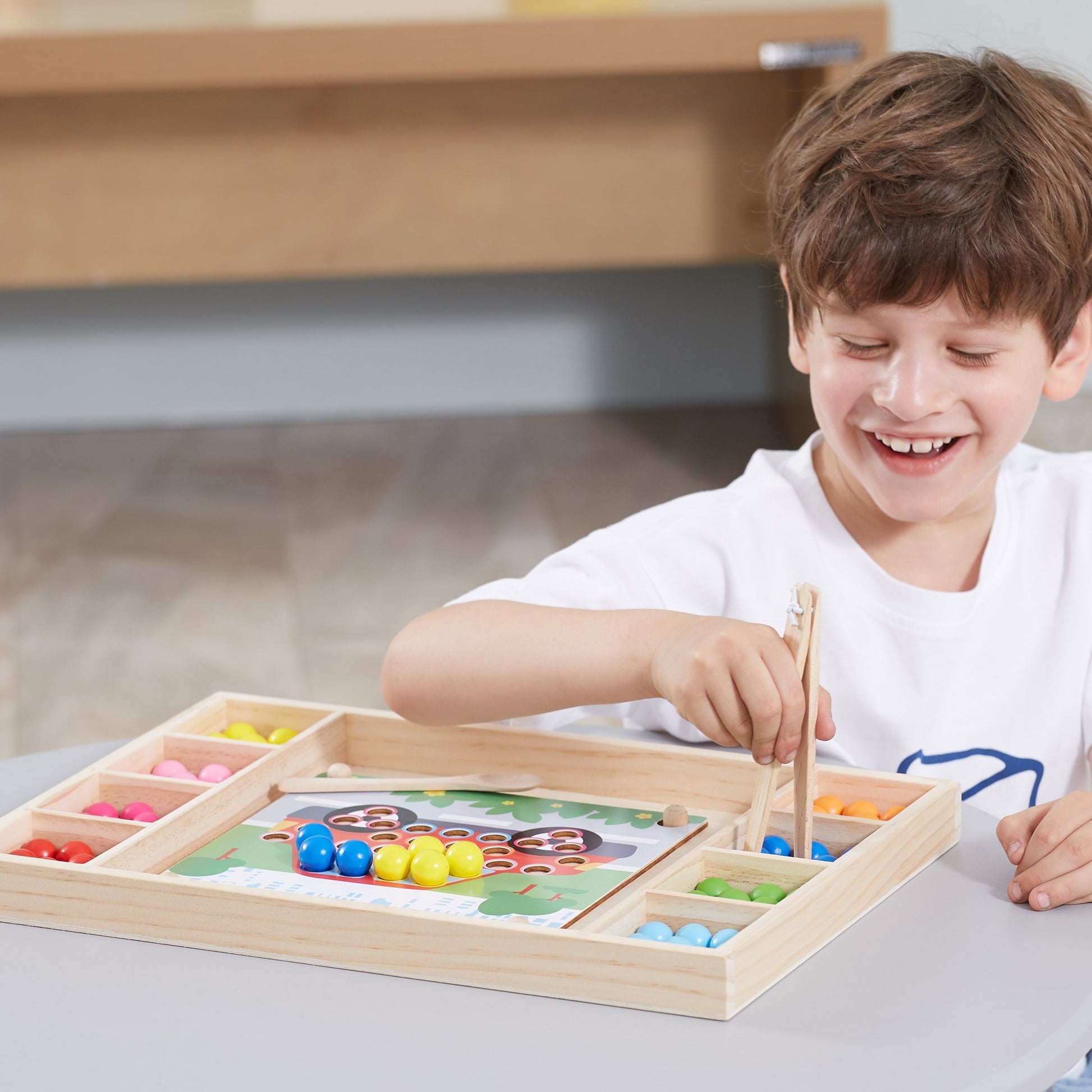 bold wooden catch and match montessori puzzle with vibrant beads and tools on a bright yellow background