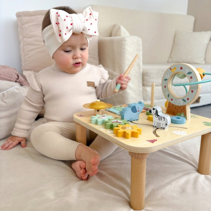 close-up of the woopie green activity table's vibrant ball track in motion
