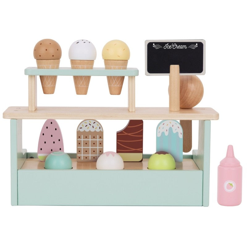 a child's hand placing a magnetic ice cream scoop on a wooden cone at the woopie green stand