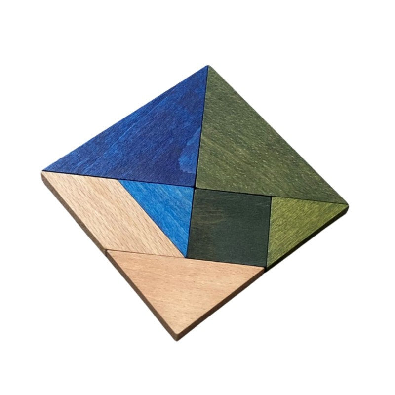 a child's hand arranging the cool-toned wooden tangram pieces into a playful animal shape on a sunlit table