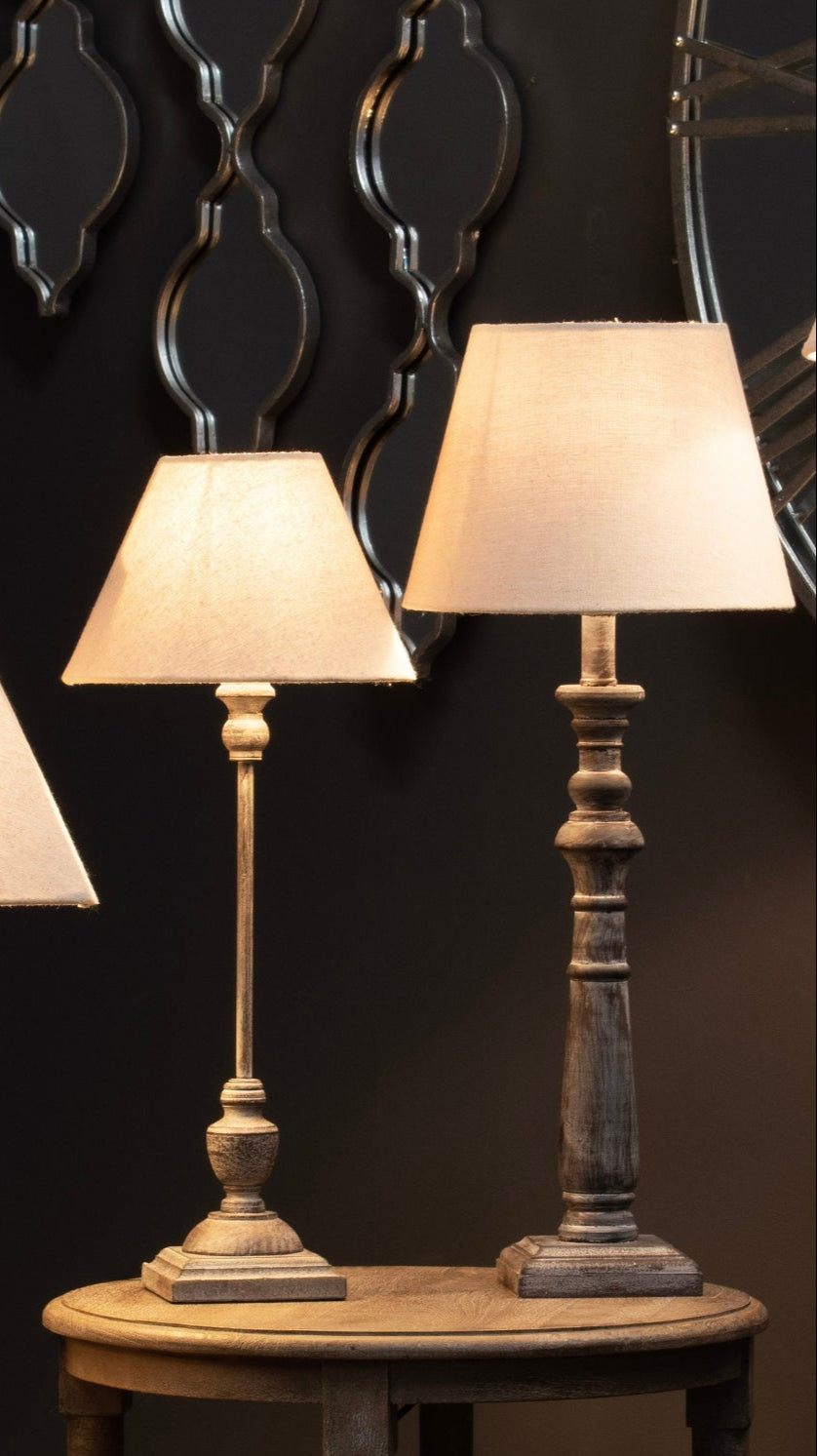 a soft, cozy glow from a grey-washed wooden table lamp with a natural linen shade